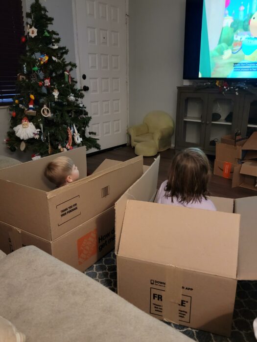 Dos niños en Navidad viendo la televisión desde cajas