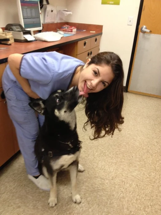 Enfermera sacando la lengua junto a su perro que también saca la sauya