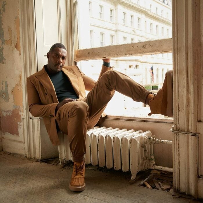Idris Elba en el alféizar de un edificio sobre el radiador