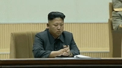 Kim Jong-un líder de Corea del Norte aplaudiendo levemente con las puntas de sus dedos y con una expresión aburrida