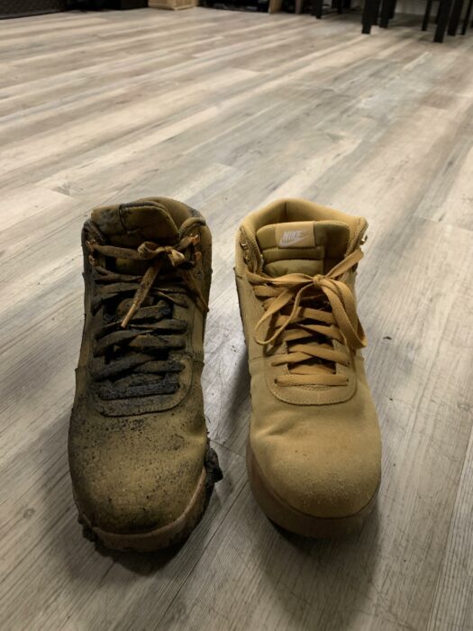 Un par de zapatos zapatillas tenis nike amarillos mostaza nuevos uno de los cuales se sumergió en un charco de lodo sucio