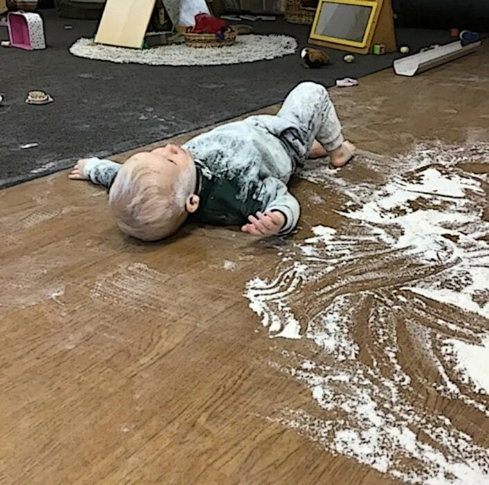 Niño acostado en el suelo sobre desastre de harina