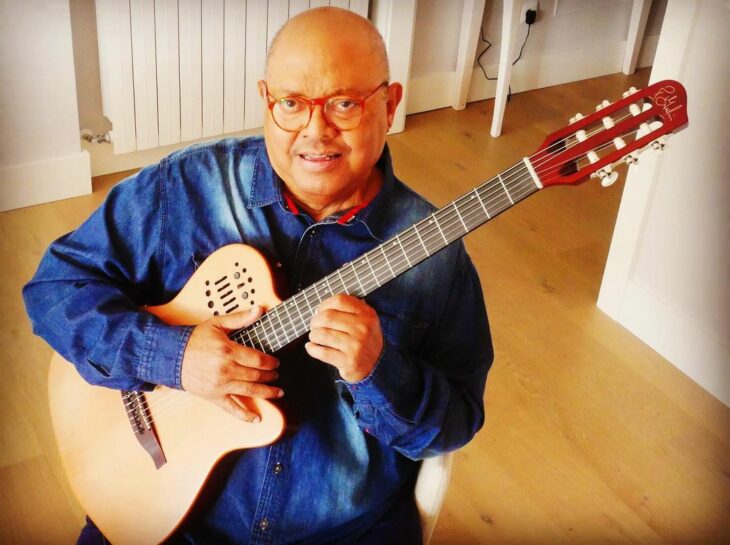 Pablo milanés tocando la guitarra con una camisa azul