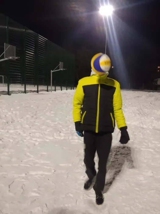 Hombre en campo nevado siendo golpeado en la cara por una bola de voléibol