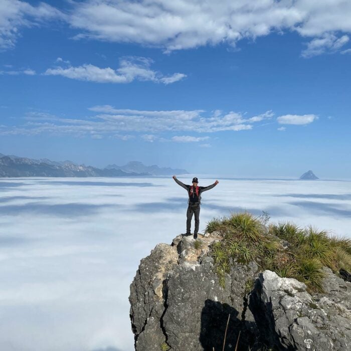 Fernando Villatoro senderista en día de celebración ascenso 365 de 2022 del Cerro de la SIlla posando con los brazos extendidos junto al abismo para la foto