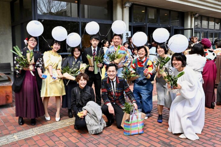 Graduadaos de la universidad de arte en tokio con lámparas en la cabeza