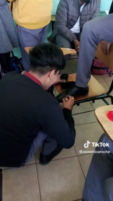 Alumno lustra los zapatos de sus compañeros