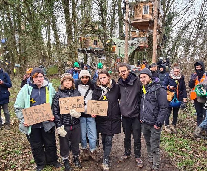 Greta Thunberg junto a otos activistas sosteniendo pancartas conta la minería de carbón en Alemania