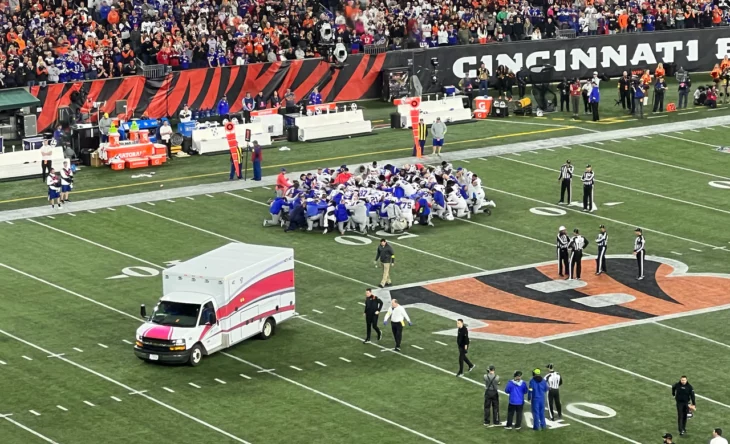 Partido de los bills y bengals cuando damar hamlin cayó desfallecido por un ataque al corazón es rodeado por sus compañeros de equipo y una ambulncia se prepara para llevárselo al hospital