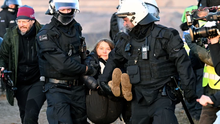 Greta Thundberg activista medioambientalista sueca siendo cargada por autoridades alemanas