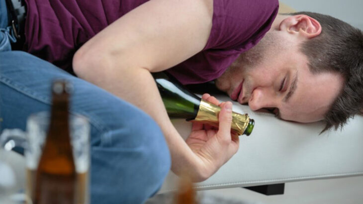 Hombre tirado con una botella