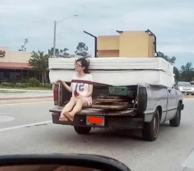 Mujer en camioneta con colchones atrás