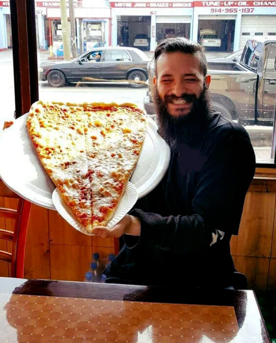 Así se ve un hombre feliz al lado de una pizza