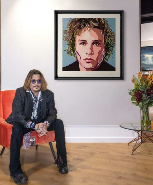 Johnny Depp posando frente a su cuadro 
