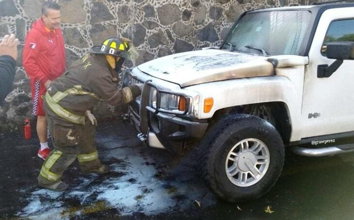 Alfredo Adame viendo a los bomberos extinguir el fuego de su camioneta Hummer