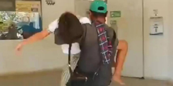 Estudiante cargada por padre de familia