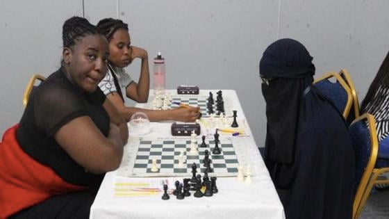 Stanley Omondi disfrazado con burka y jugando ajedrez