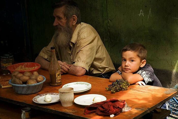 Niño comiendo con su abuelo